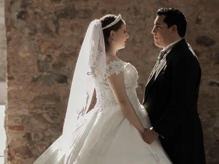 Novios frente a un muro de piedra en una boda organizada por membē en Zacatecas